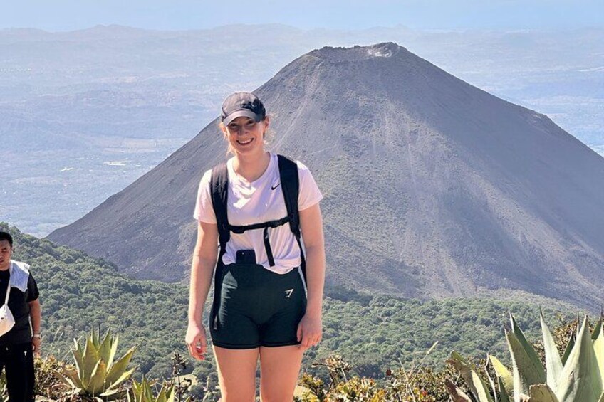 A traveler is posing in front of the santa ana volcano crater 2