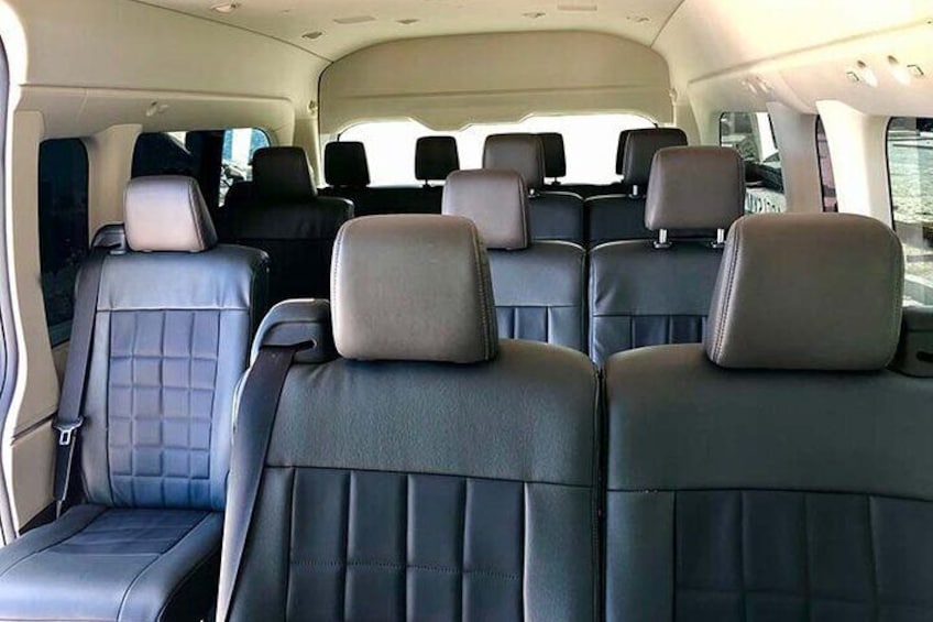 A vehicle interior with multiple rows of seats, headrests, and a central aisle. 5
