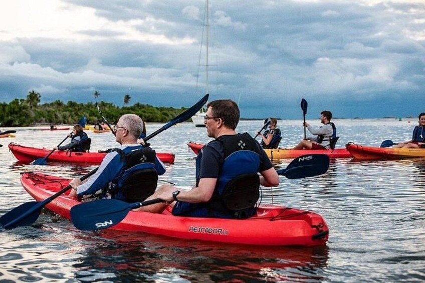 People kayaking on calm water with a cloudy sky. 4