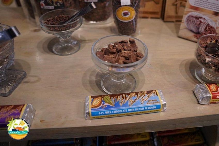 A chocolate bar, a glass bowl with chocolate pieces, and a jar of chocolate spread on a table. 5