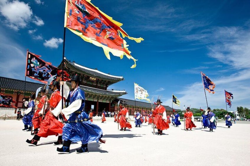 A traditional dance performance in front of a historic building with flags. 4