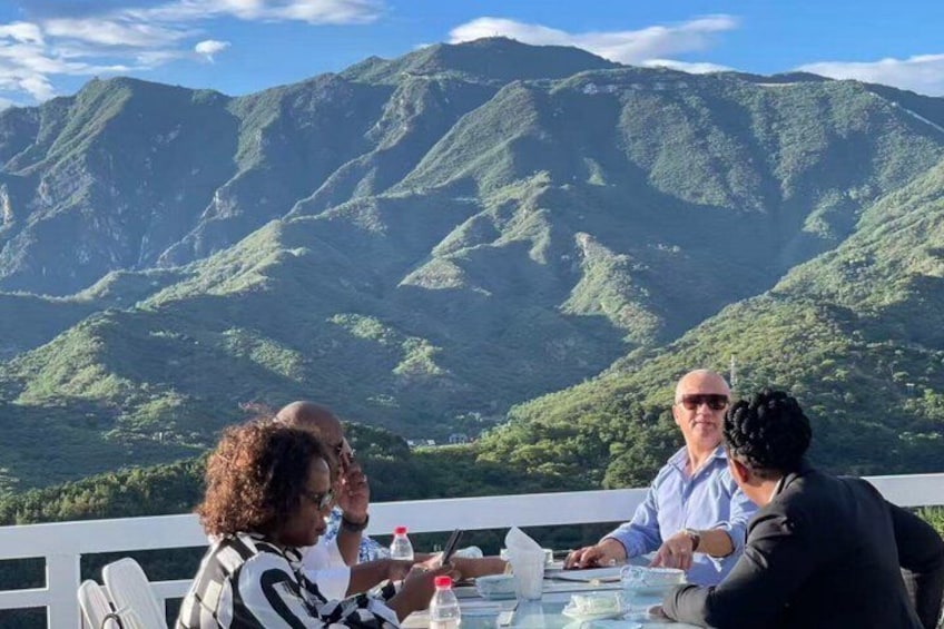 A group of people dining at a table with a mountainous landscape in the background. 4