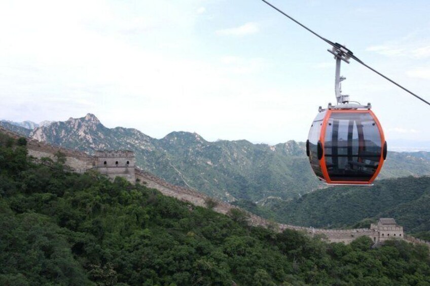 A cable car over a mountainous landscape with the Great Wall of China in the background. 5
