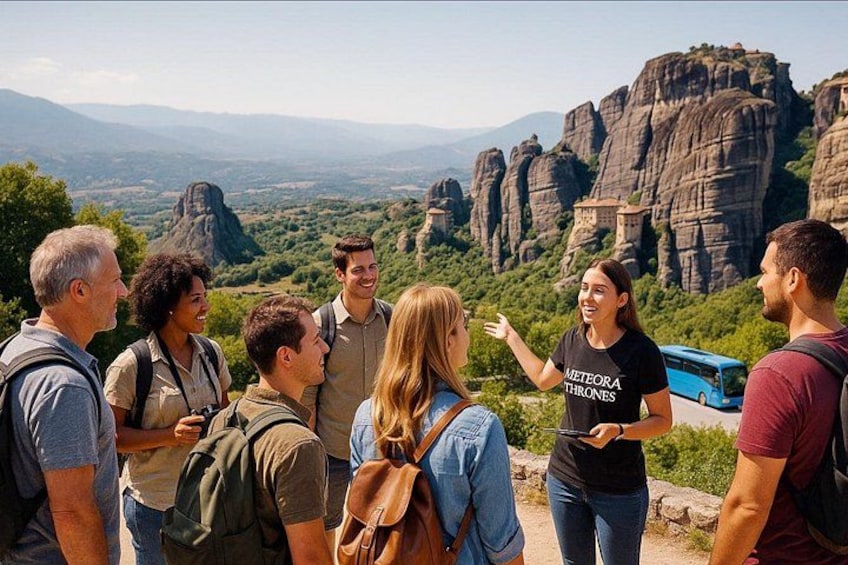 A group of people standing on a hill overlooking a mountainous landscape with a bus in the background. 5