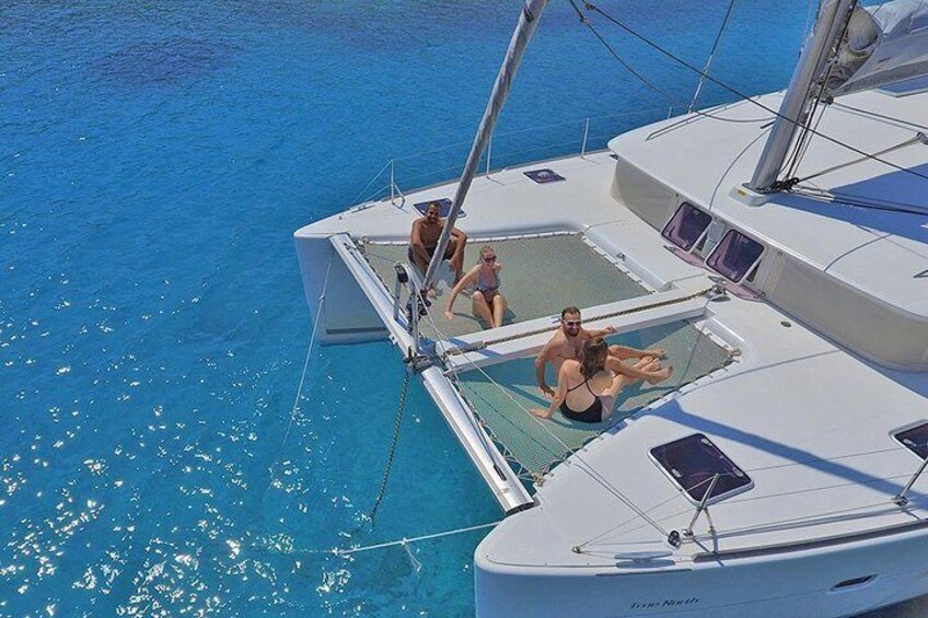 Un yate blanco con gente en la cubierta, rodeado de aguas azul cristalino. 2