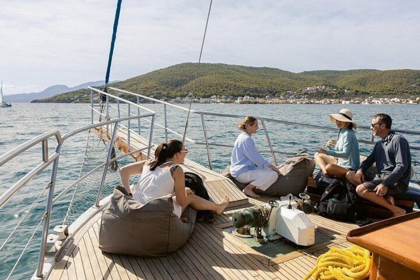 A group of people on a sailboat with a mountainous landscape in the background. 4