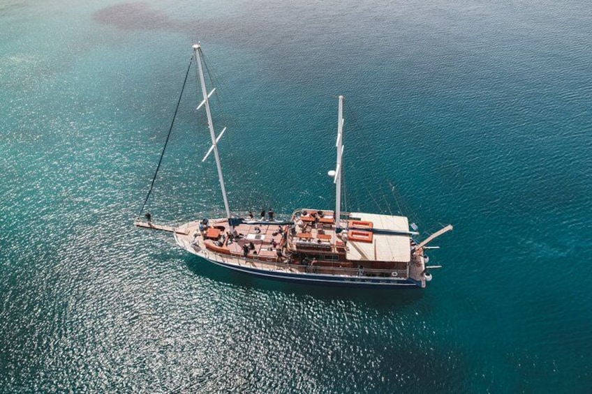 Vista aérea de un velero con varios mástiles y pasajeros en la cubierta. 1