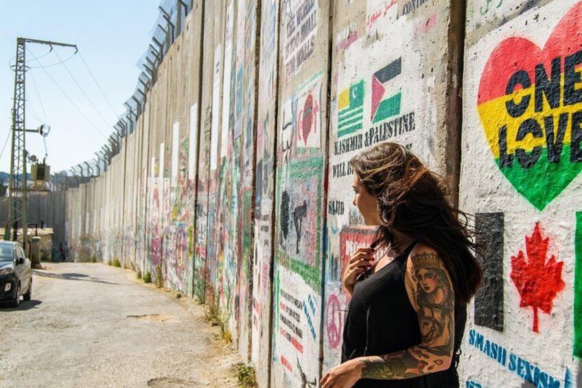 A wall with graffiti and a person standing beside it. 4