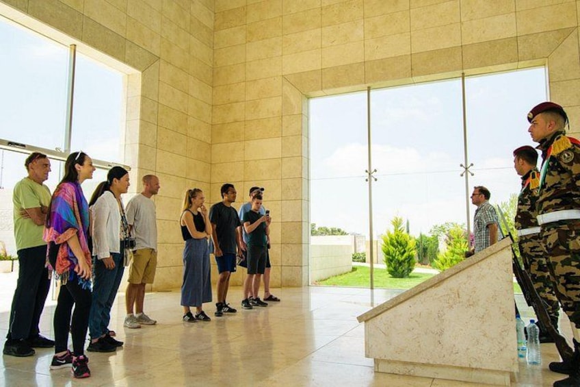 A group of people standing in a modern building with large windows. 5