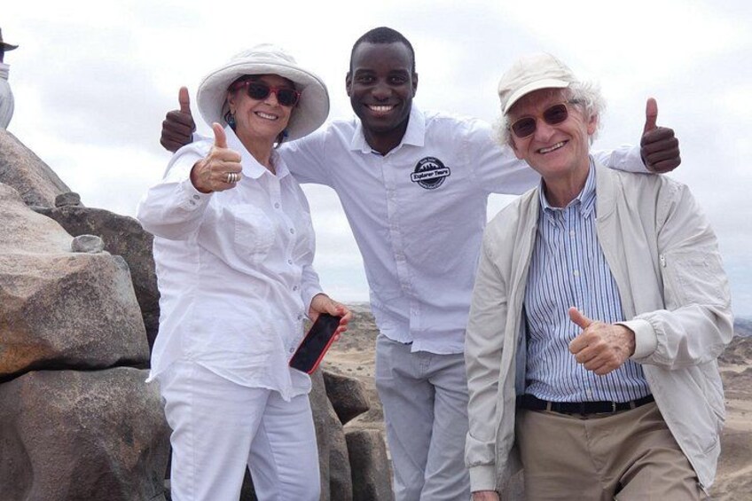 Three people giving thumbs up in a rocky outdoor setting. 2
