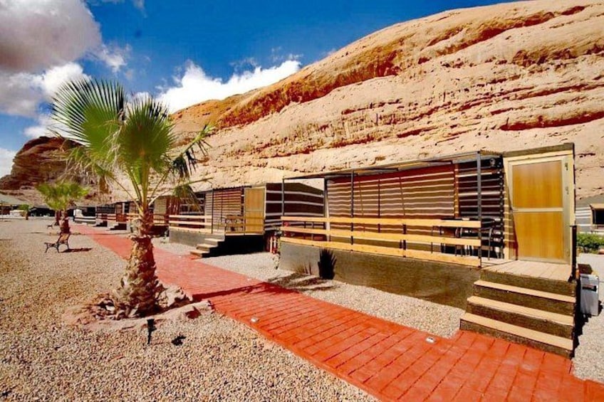 Een modern gebouw met een rode bakstenen pad, palmbomen en een woestijnlandschap. 3