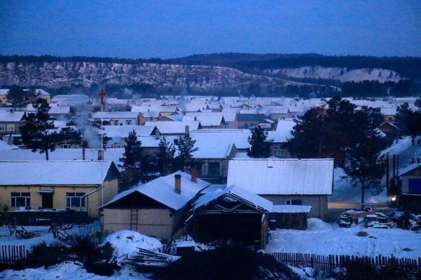 A snow-covered town with houses, a church, and a hill in the background. 4