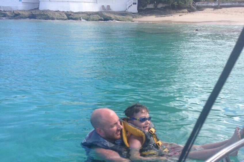 Un hombre y un niño en un bote sobre aguas turquesas. 4