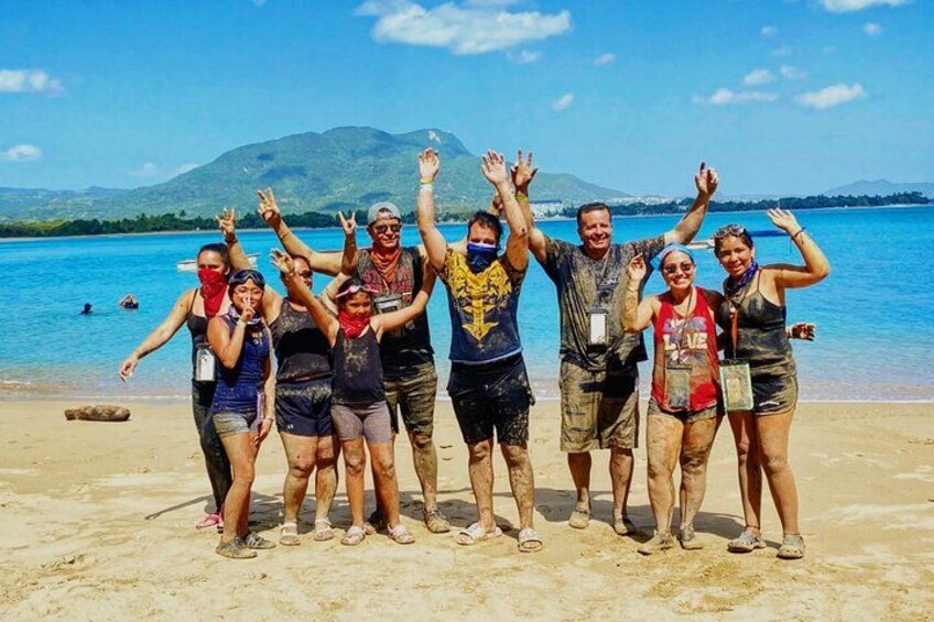 A group of people on a beach with a mountain in the background. 3