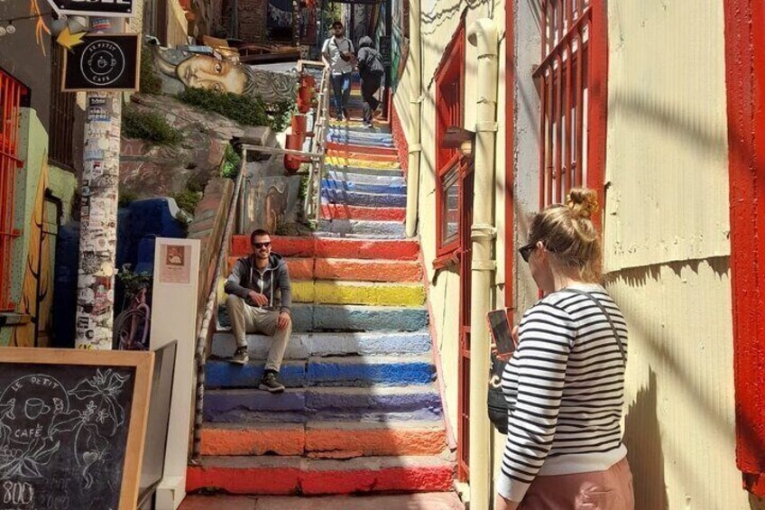 A colorful staircase in a narrow alleyway with people walking up and down. 4