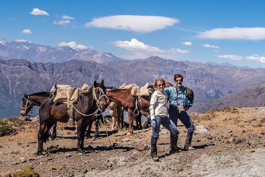 A mountainous landscape with horses and people. 2