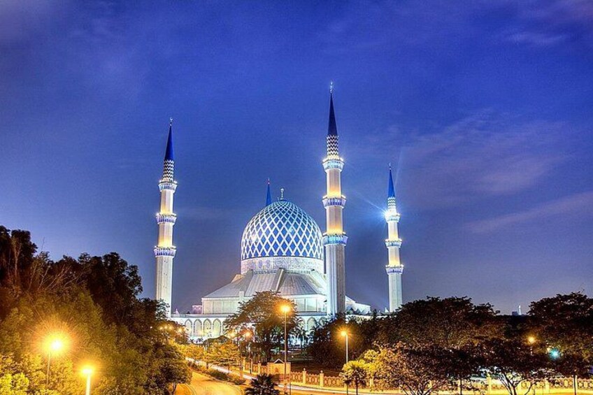 A mosque with a large central dome and four minarets, surrounded by trees and streetlights. 2