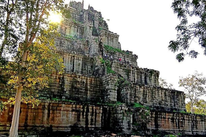 A large, ancient stone structure with multiple levels and terraces, surrounded by trees. 2