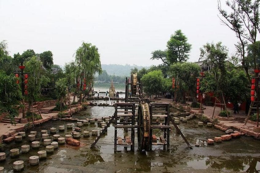 A traditional water wheel structure surrounded by stone steps and greenery. 3