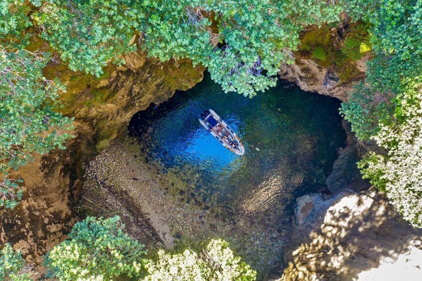 Un bateau sur une étendue d’eau naturelle, entouré de falaises rocheuses et de végétation. 5