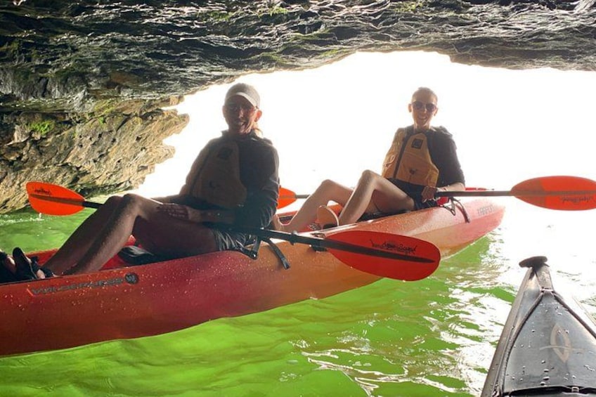 Dos personas remando en kayak dentro de una cueva con agua. 4