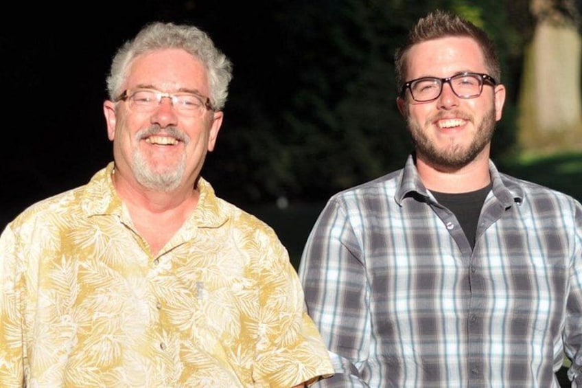 Two people standing outdoors, one in a yellow shirt and the other in a plaid shirt. 3