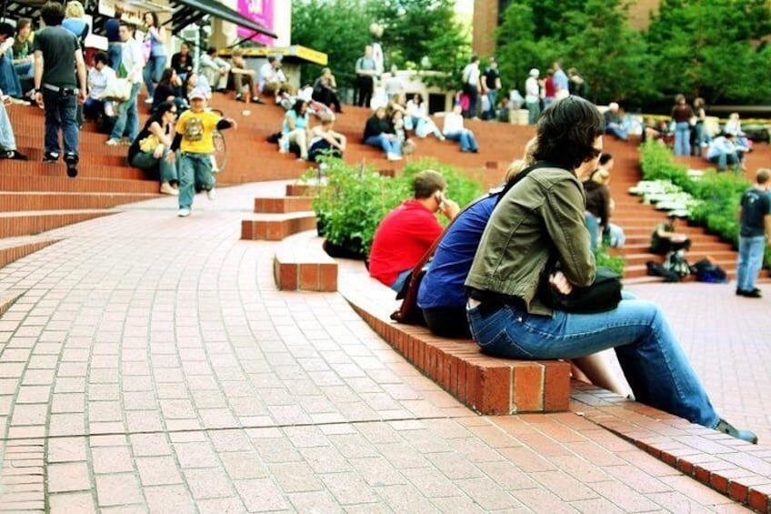 A curved brick pathway with people sitting and walking. 4