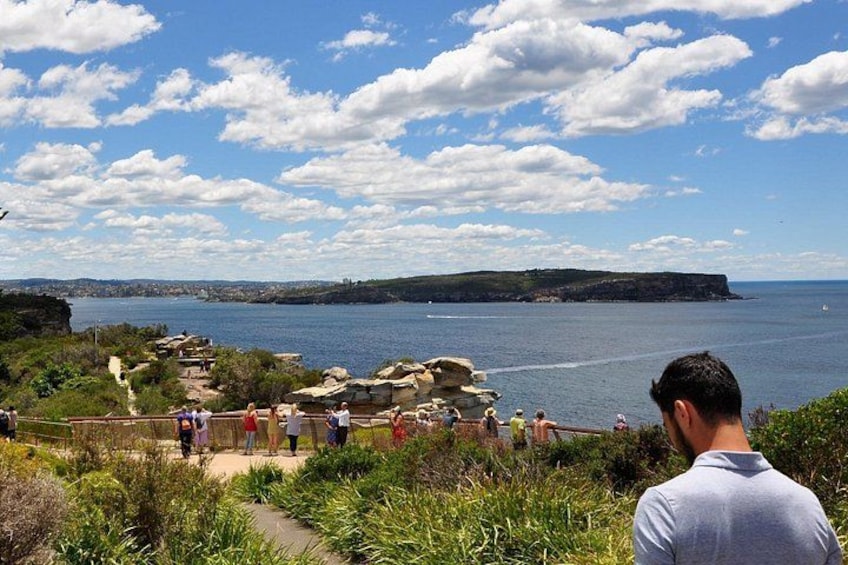 Un paysage côtier avec un promontoire rocheux, un ciel dégagé et une vue lointaine sur la mer. 1