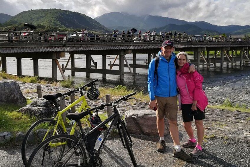 A wooden bridge over a body of water with mountains in the background. 5
