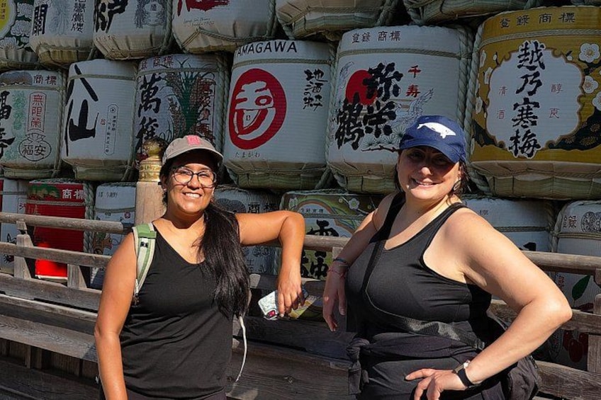 Two people standing in front of a stack of large bags with Japanese characters. 3