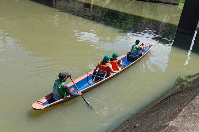 Un bateau étroit sur lequel se trouvent quatre personnes qui rament sur une rivière paisible. 3