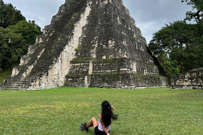 Una gran estructura piramidal con escalones que conducen a su cima, rodeada de abundante vegetación. 3