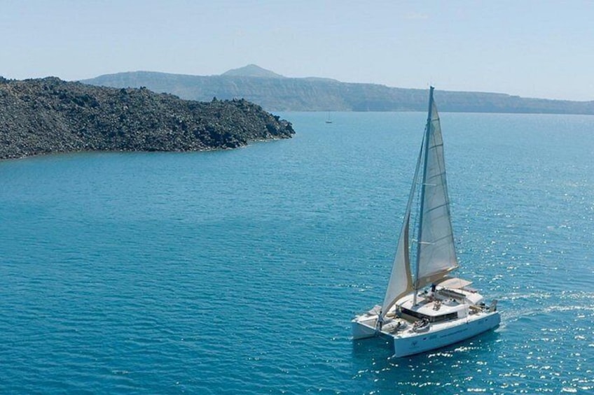 En sejlbåd på et roligt hav med en klippeø i baggrunden. 3