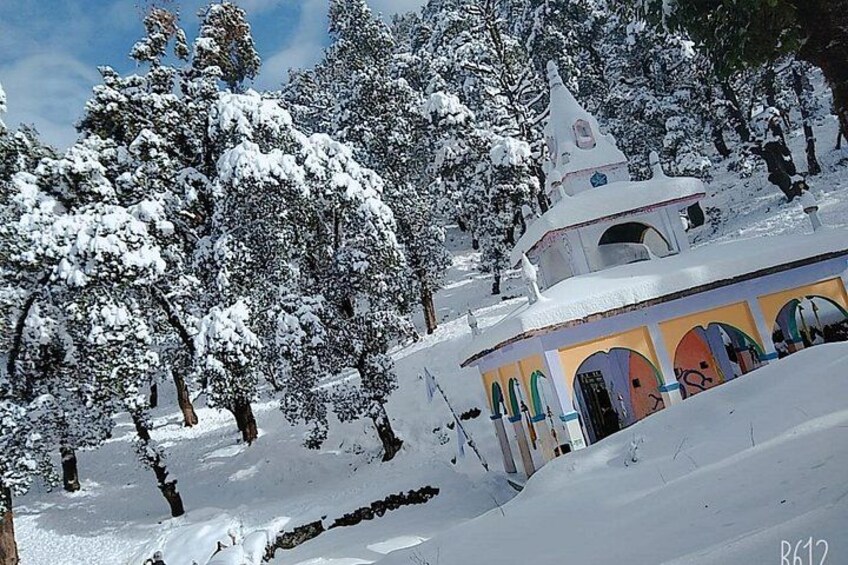 A snow-covered landscape with a distinctive building featuring arched windows and a bell tower. 4