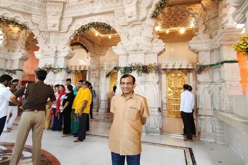 A man standing in a temple with ornate architecture and floral decorations. 3