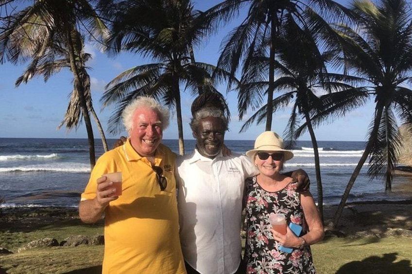 Tres personas sobre una playa con palmeras y el océano al fondo. 2