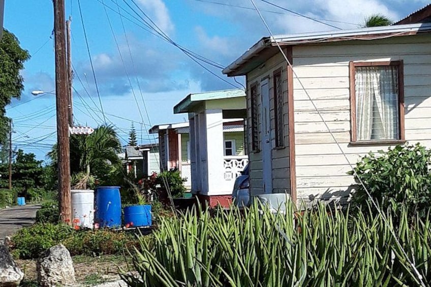 Una hilera de casas de una sola planta, cielo despejado y líneas eléctricas. 1