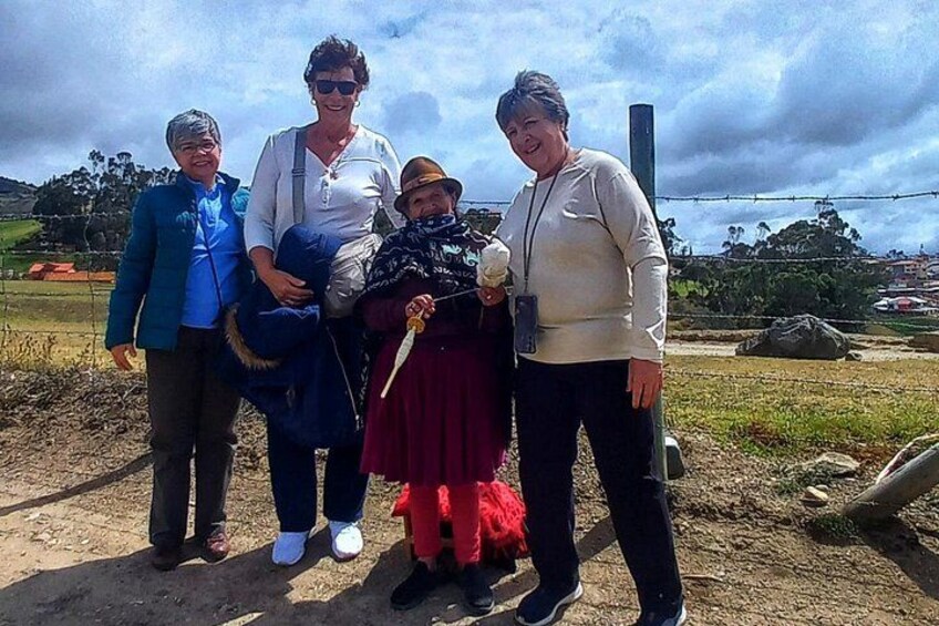 A group of people standing outdoors with a cloudy sky and a rural landscape in the background. 1