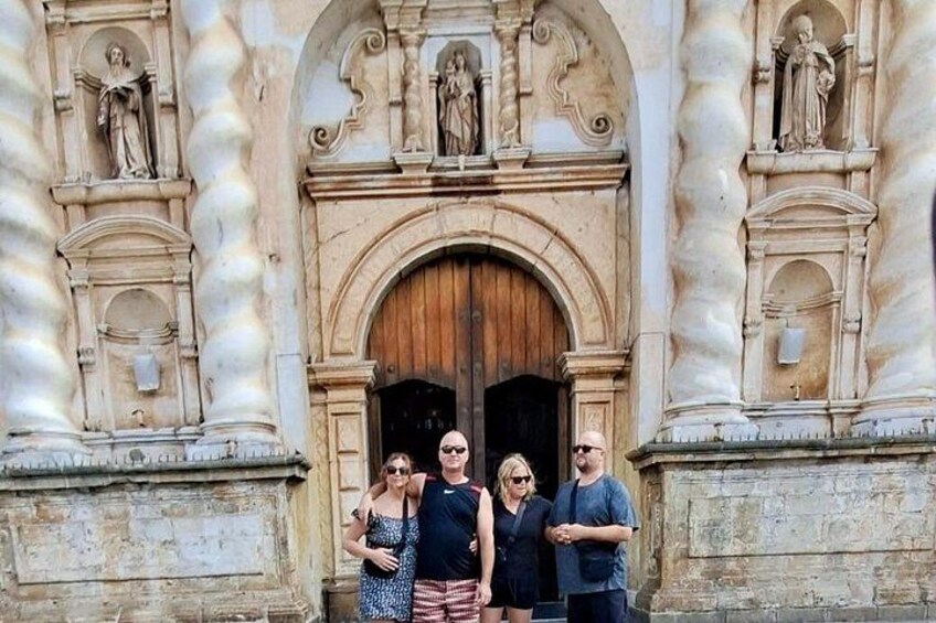 A group of people standing in front of a historic building with ornate architecture and statues. 4