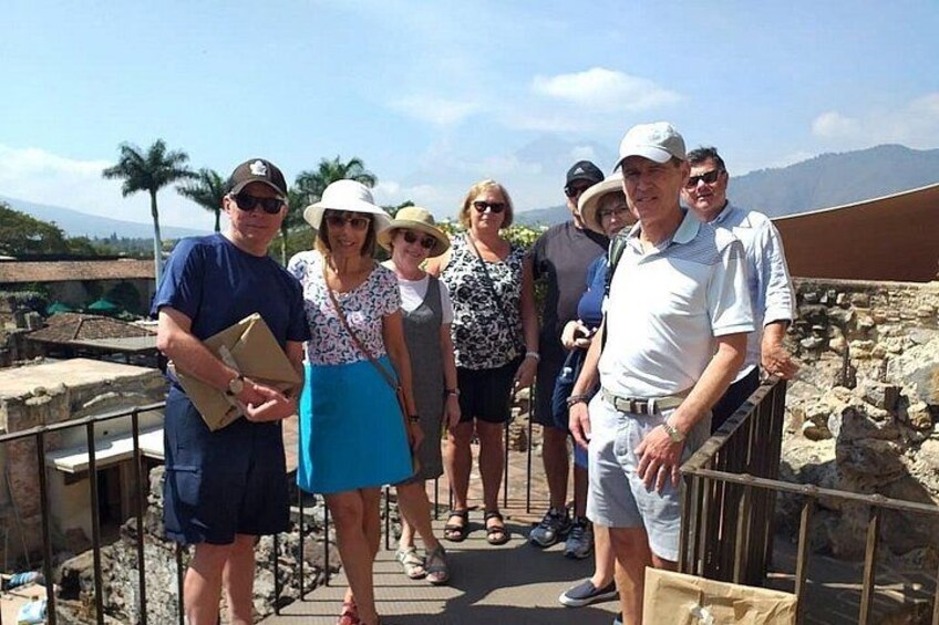 A group of people standing on a stone pathway with ruins in the background. 5