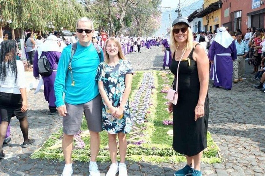 A group of people standing on a cobblestone street with a floral arrangement in the foreground. 5