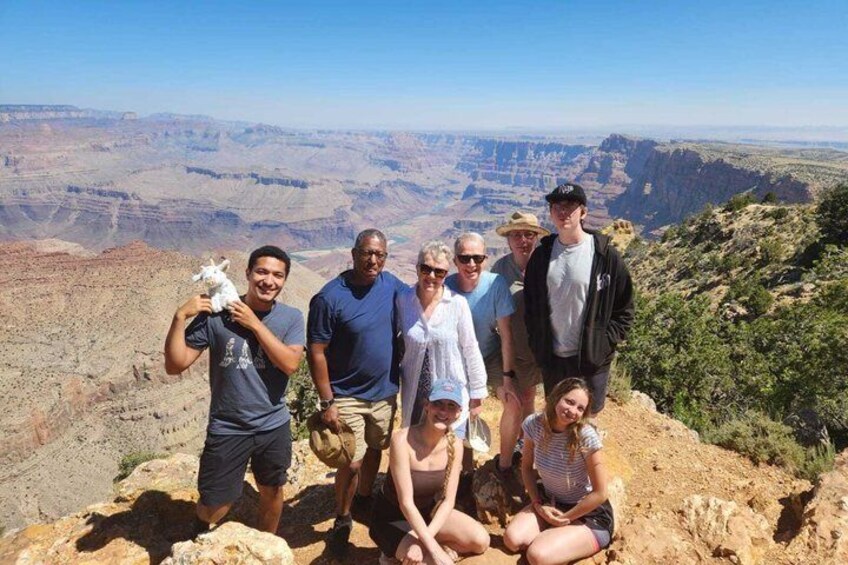 Un gruppo di persone su una sporgenza rocciosa con vista su un canyon. 4