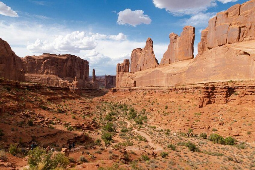 A desert landscape with prominent red rock formations and sparse vegetation. 5