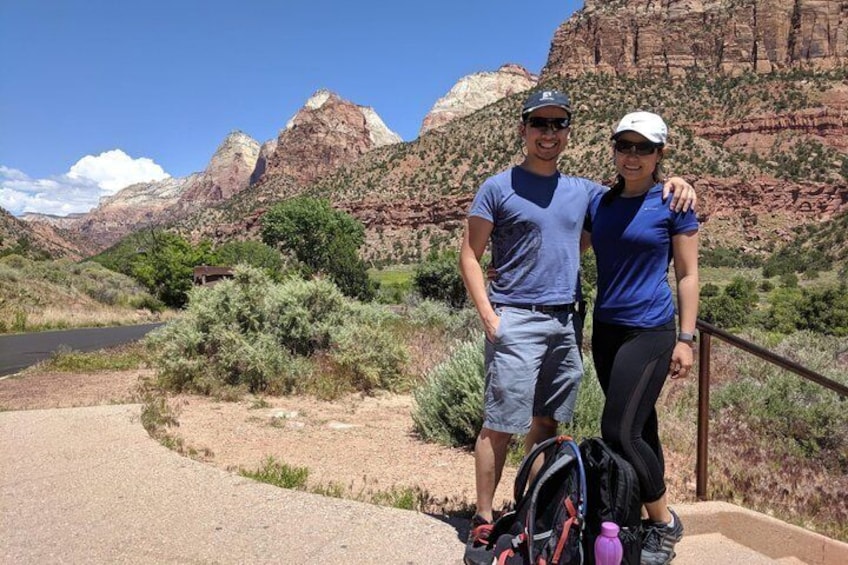 A couple standing on a trail with a mountainous landscape in the background. 2