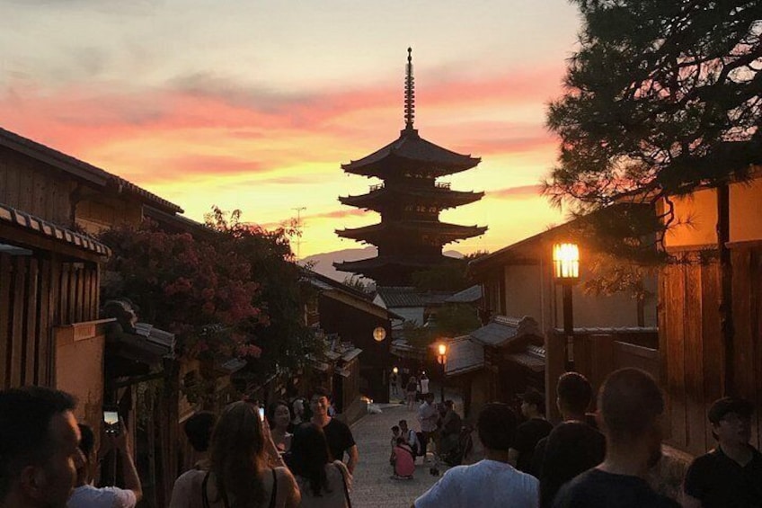 A traditional Japanese temple with a pagoda, surrounded by people and traditional buildings. 1