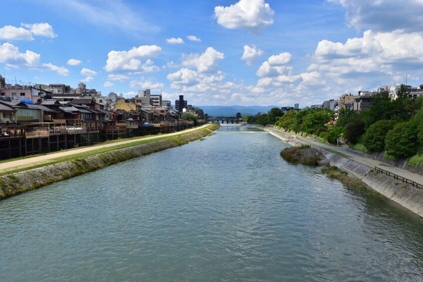 Un río con un puente a lo lejos, rodeado de edificios y vegetación. 3