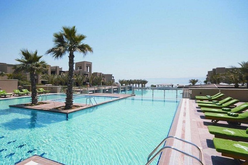 A swimming pool with palm trees and lounge chairs. 1