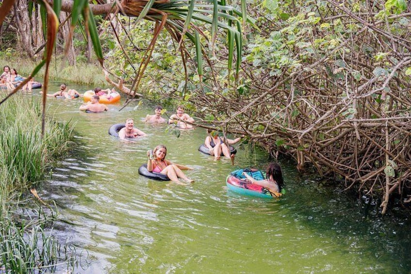 People floating on tubes in a natural waterway surrounded by vegetation. 5
