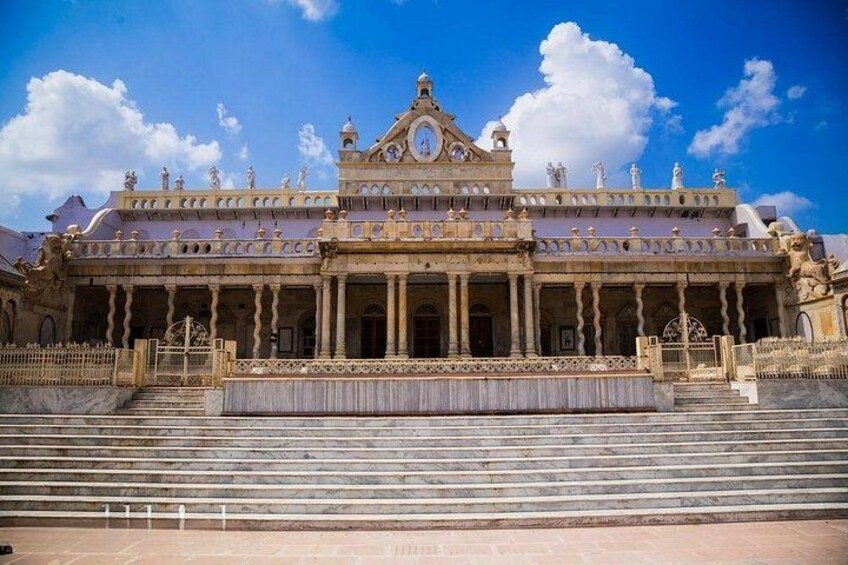 A grand, ornate building with a central dome, multiple statues, and a large staircase leading to the entrance. 3