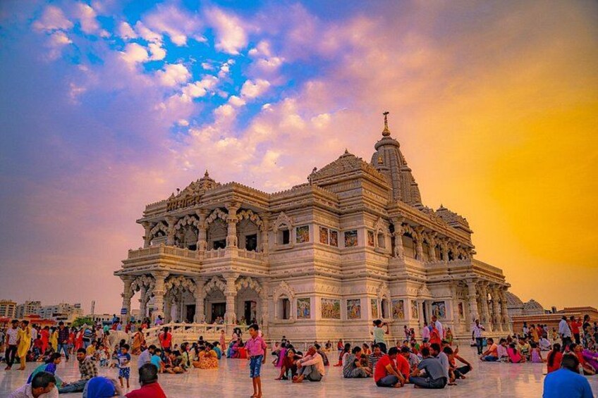 A large, ornate temple with intricate architecture and a crowd of people gathered around it. 1